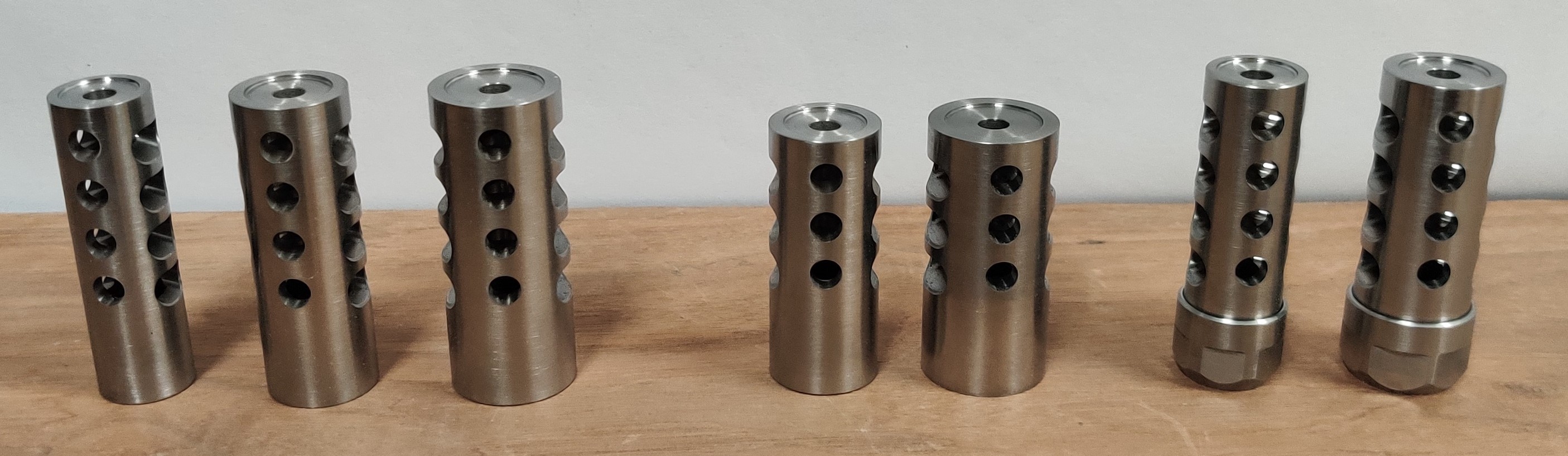 six muzzle brakes, side by side